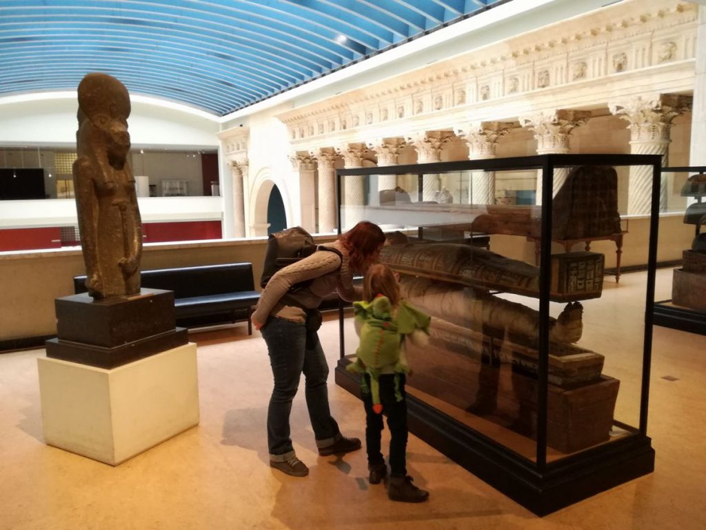 Mom showing Febe the interior of an Egyptian sarcophagus.